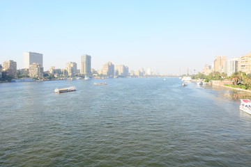 Fototapeta premium Nile river in Cairo Egypt during the day with boats running and high building surrounding river banks