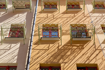 Fototapeta na wymiar Facade of a residential building with small balconies in front of the window