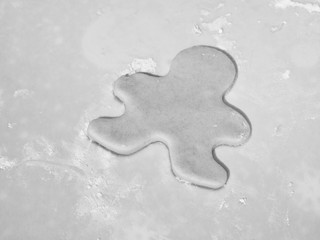 A closeup vintage looking black and white photograph of a single gingerbread man shaped Christmas...