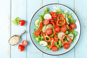 Healthy vegetarian vegetable salad of fresh lettuce, cucumber, sweet pepper and tomatoes. Vegan plant-based food. Flat Lay. Top view