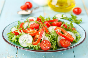 Healthy vegetarian vegetable salad of fresh lettuce, cucumber, sweet pepper and tomatoes. Vegan plant-based food. Flat Lay. Top view