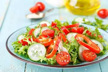 Healthy vegetarian vegetable salad of fresh lettuce, cucumber, sweet pepper and tomatoes. Vegan plant-based food. Flat Lay. Top view