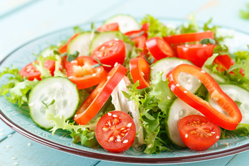 Healthy vegetarian vegetable salad of fresh lettuce, cucumber, sweet pepper and tomatoes. Vegan plant-based food. Flat Lay. Top view