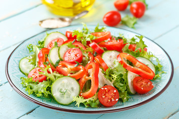Healthy vegetarian vegetable salad of fresh lettuce, cucumber, sweet pepper and tomatoes. Vegan plant-based food. Flat Lay. Top view