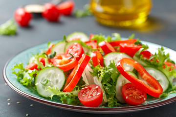 Healthy vegetarian vegetable salad of fresh lettuce, cucumber, sweet pepper and tomatoes. Vegan plant-based food. Flat Lay. Top view
