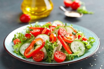 Healthy vegetarian vegetable salad of fresh lettuce, cucumber, sweet pepper and tomatoes. Vegan plant-based food. Flat Lay. Top view