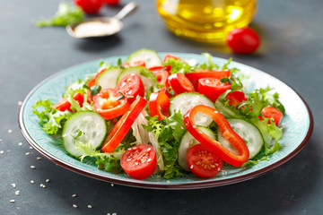 Healthy vegetarian vegetable salad of fresh lettuce, cucumber, sweet pepper and tomatoes. Vegan plant-based food. Flat Lay. Top view