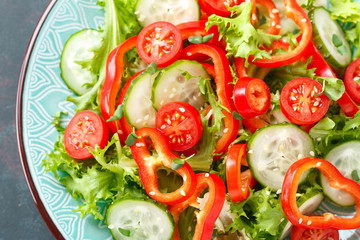 Healthy vegetarian vegetable salad of fresh lettuce, cucumber, sweet pepper and tomatoes. Vegan plant-based food. Flat Lay. Top view