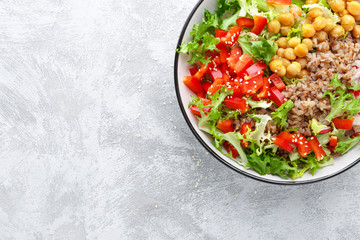 Healthy and delicious bowl with buckwheat and salad of chickpea, fresh pepper and lettuce leaves. Dietary balanced plant-based food. Vegan and vegetarian dish. Top view. Flat lay