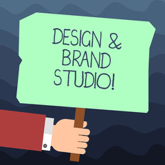 Text sign showing Design And Brand Studio. Conceptual photo Modern designing space professional office Hu analysis Hand Holding Blank Colored Placard with Stick photo Text Space