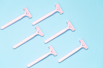 Pink female razors isolated on the blue background. Set of razors on blue background. Pink women's disposable razors . Hygiene skin body care concept. Hair removal.