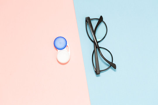 Glasses and contact lenses on two color pastel background, vision concept