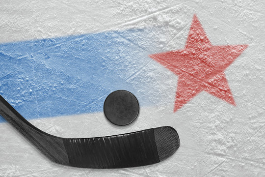 An image of a blue line with a red star on ice and a stick with a puck