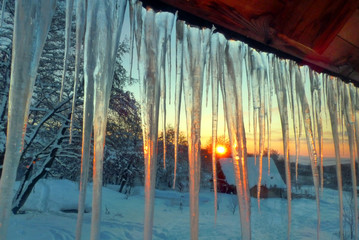 Long Icicles hanging from winter cabin roof