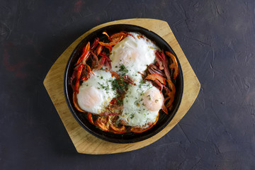 Fried eggs with bacon, bell pepper and tomato