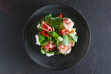 Fresh salad with jamon, mozzarella, tomato and olives