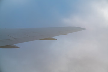 wing of an airplane flying above the clouds