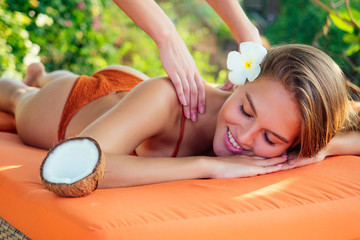 Ayurvedic relaxing massage ,health beauty happy closed eyes woman in spa salon getting massage on the holiday beach.Beautiful girl enjoying day spa resort, lying down on the table treatment procedure