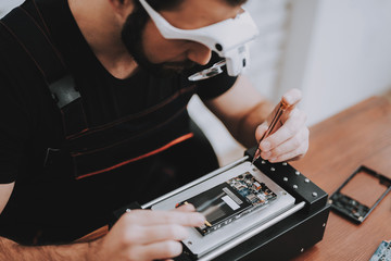 Man Repairing Hardware Equipment in Repair Shop