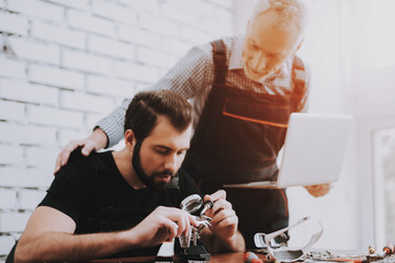 Two Men Repairing Hardware Equipment in Workshop.