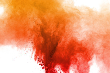 Freeze motion of orange powder exploding on white background.