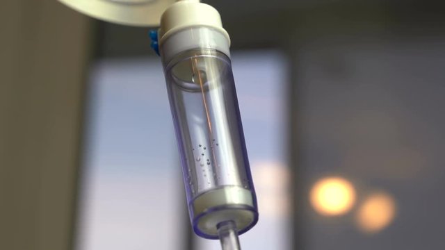 Dripping of iv saline solution in hospital, close up