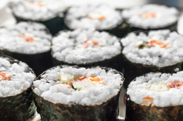 Chumaki Sushi Rolls with Tuna, Salmon, Rice, Cucumber, Avocado And Nori Seaweed on a Plate.