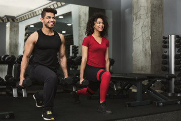 Sports people working out with dumbbells in gym