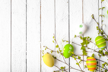 Wooden background with easter egg decoration. Painted eggs on white wood.