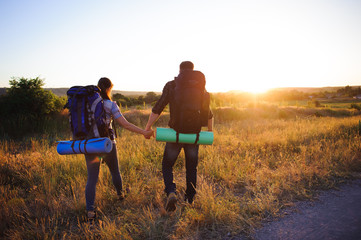 travelers with backpack walking  in sunset