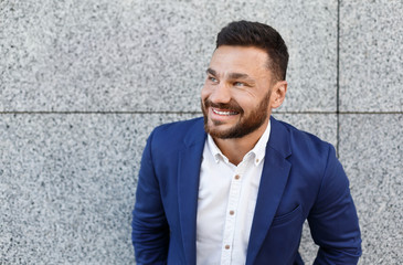 Successful businessman standing in front of office building