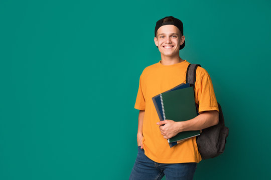 Teen guy with books and backpack over background