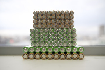 Electric batteries and accumulators size AAA AA lot of green in the package in the store. Shallow depth of field