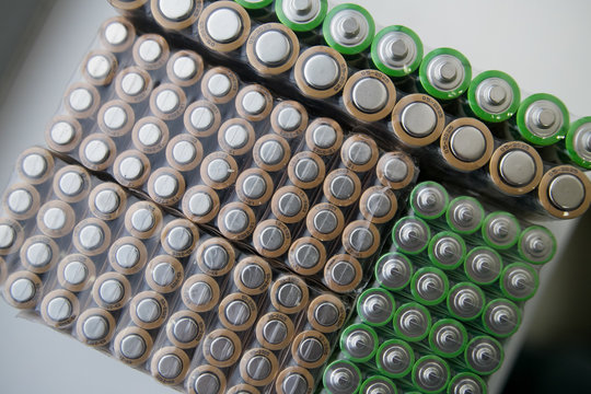 Electric batteries and accumulators size AAA AA lot of green in the package in the store. Shallow depth of field