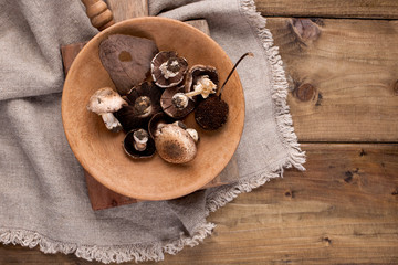 Mushrooms in a pan on a wooden background. Vintage photo and napkin in rustic style. Free space for text, top view.