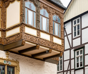 Fototapeta na wymiar Simple half-timbered façade in the background and richly carved half-timbered house on an oriel in the old town