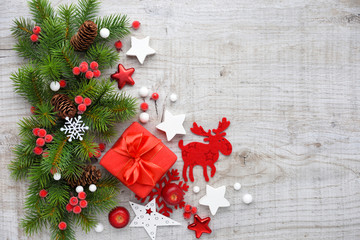 Christmas decorations and spruce branches on a wooden background. Top view, copy space. Christmas or New Year greeting card.