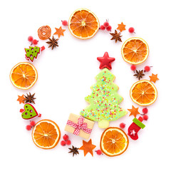 Round frame with dried orange, christmas cookies, anise stars on white background. Flat lay, top view