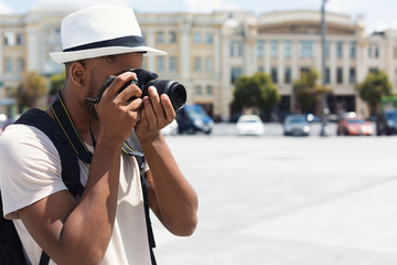African-american man taking photos on camera, copy space