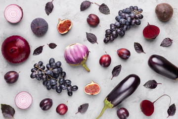 Collection of purple fruits and vegetables on gray background
