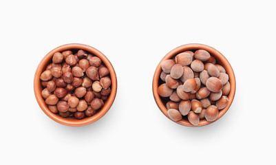 Peeled and unpeeled hazelnuts in ceramic bowls