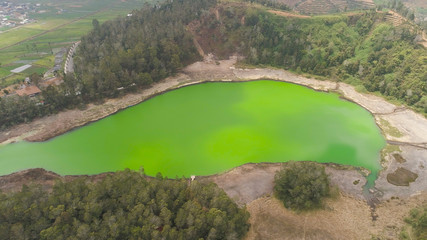 Fototapeta premium volcanic sulfur lake telaga warna in dieng plateau, java Indonesia. mountain tropical landscape lake with green water among mountains. this lake is one mainstay tourist destinations in Wonosobo