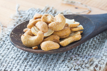 Dried Cashew Nuts on wooden ladle (close-up shot)
