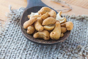 Dried Cashew Nuts on wooden ladle (close-up shot)