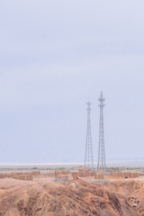Telephone towers and brick houses in the middle of gobi desert near the historical site of Yang Pass, in Yangguan, Gansu, China