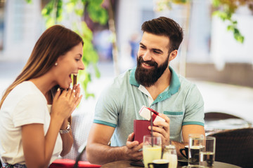 Man surprises woman with a gift in cafe