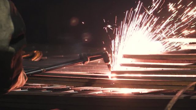 sparks coming from steel cutting. Industrial worker cutting metal by using gas torch