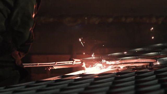 Industrial worker cutting metal with gas torch at workshop slow motion