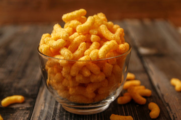 Crispy peanut puffs or flips snacks. Close-up on rustic vintage wooden table.