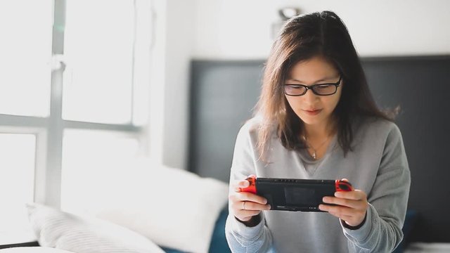 Young woman playing console game at her room.